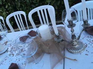 een witte tafel met stoelen en wijnglazen erop bij Villa Costantino in Pompei
