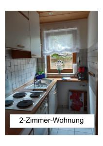 a kitchen with a stove and a sink and a window at Ferienwohnung Kugel in Landau in der Pfalz