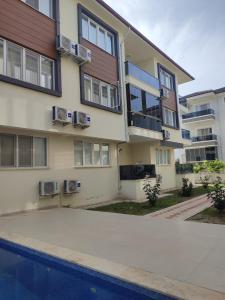 an apartment building with a pool in front of it at Umut's Hause in Bezkesen
