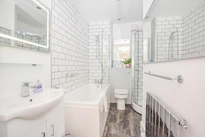 Un baño blanco con lavabo e inodoro. en Big Ben 2 Bed, en Londres 1 foto más