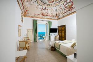 a bedroom with a bed and a ceiling with a painting at Albergo California in Positano