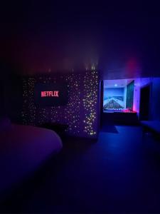 a dark room with a netflix sign on a wall at L'Évasion des Sens - Spa Sauna Hammam Jacuzzi in Bray-sur-Somme