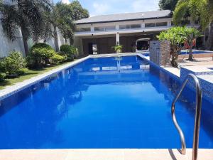 ein großer blauer Swimmingpool neben einem Gebäude in der Unterkunft Villa Angelica Private Resort and Venue in San Juan + 20 Fotos