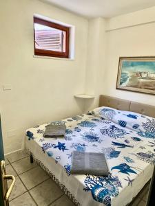 Un dormitorio con una cama con un edredón azul y blanco. en Eden Beach Appartamento Tamerici, en Marina di Sorso
