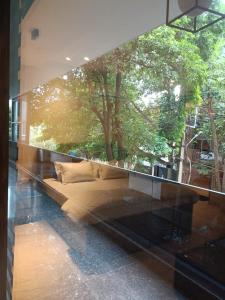 a glass wall with a couch in front of a window at Anant in Jāmb