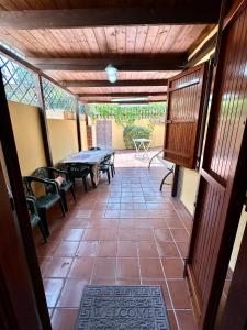 Habitación con mesa, sillas y patio. en Eden Beach Appartamento Tamerici, en Marina di Sorso