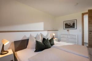 a bedroom with a large white bed with pillows at Appartement "Am Brummelbach" in Westendorf