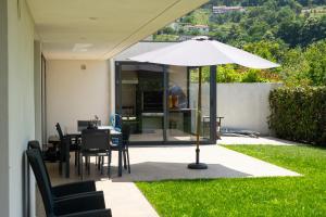 a patio with an umbrella and a table and chairs at Casa Horizontes de Arouca in Arouca