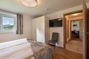a bedroom with a bed and a chair and a desk at Appartement "Am Brummelbach" in Westendorf