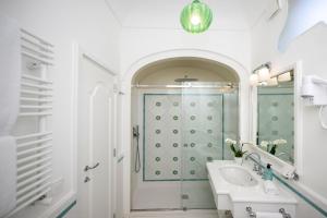 a white bathroom with a sink and a shower at Albergo California in Positano +86 photos
