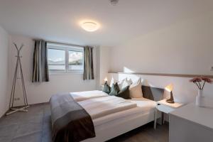 a bedroom with a large white bed with a window at Appartement "Am Brummelbach" in Westendorf