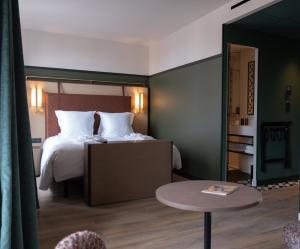 a hotel room with a bed and a table at Hotel & Spa Oceania Lille Les Augustins in Lille +34 photos