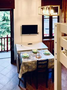 バルドネッキアにあるTiny House Campo Smithのテーブルとテレビのあるダイニングルーム