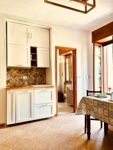 バルドネッキアにあるTiny House Campo Smithの白いキャビネットとテーブル付きのキッチン