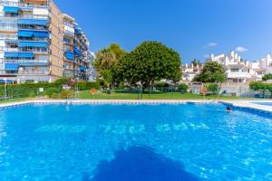 a large blue swimming pool in front of a building at Mar del Sur in Benalmádena