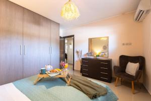 a bedroom with a bed and a chair and a table at Villa Eleanna Pastras Residence in Vanáton