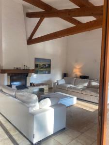 een woonkamer met witte banken en een open haard bij Les Bosquets in Lorgues