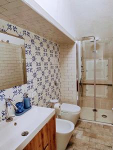 a bathroom with a sink and a toilet and a shower at Casetta Bianca Luxury in Santa Flavia +29 photos