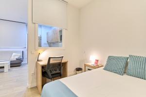 a bedroom with a bed and a desk and a chair at Paraíso Suites by gaiarooms in Valladolid