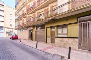 a red car parked on a street next to a building at Paraíso Suites by gaiarooms in Valladolid