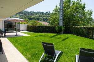 a yard with two chairs and an umbrella at Casa Horizontes de Arouca in Arouca