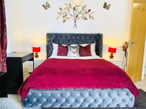 a bedroom with a large bed with a red blanket at Igloo Magnolia Room Stay I Breakfast I Free Parking in Leeds
