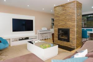 a living room with a fireplace and a tv at Casa Horizontes de Arouca in Arouca