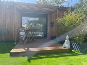 una terrazza in legno con 2 sedie in giardino di Maison 4 chbs avec jacuzzi, au pied de la piste cyclable a Lacanau-Océan
