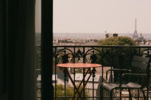 a table on a balcony with a view of the eiffel tower at Terrass" Hotel in Paris