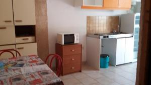 a small kitchen with a table and a microwave at Camping Europa Beach in Castellare-di-Casinca