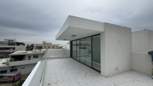 a large white building with glass doors on a balcony at Central luxury 3 bedroom villa with pool in Paphos City