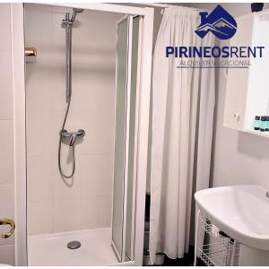 a bathroom with a shower curtain and a sink at Apartamentos Pirineos Rent in Candanchú +26 photos