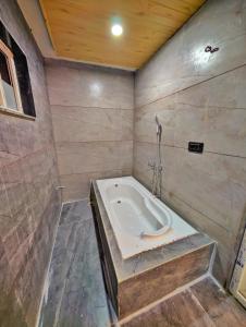 a bathroom with a bath tub in the corner at Hotel Amaze 21 in Kota
