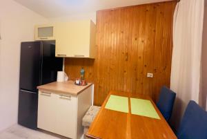 a small kitchen with a table and a refrigerator at Przytulne mieszkanie m3 Gorlice in Gorlice +13 photos