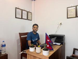 a man sitting at a desk with a computer at Ishan Home and Home Stay in Manamaiju