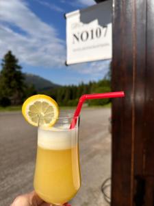 a person holding a drink with a lemon slice at No107 Predeal in Predeal