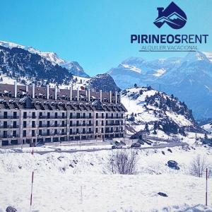 een hotel bovenop een met sneeuw bedekte berg bij Apartamentos Pirineos Rent in Candanchú