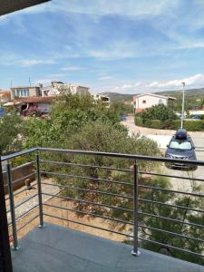 a balcony with a car parked on a street at Apartmani Katarina in Rogoznica