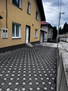 ein gelbes Gebäude mit einem gemauerten Bürgersteig neben einem Haus in der Unterkunft Sarajevo Soul in Sarajevo