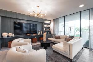 Una sala de estar con muebles blancos y un televisor de pantalla plana. en Beautiful 3 bedroom oasis close to downtown, en Austin