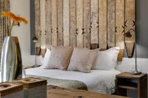 a bedroom with a bed with a wooden headboard at African Rock Hotel & Spa -"Relaxed Exclusivity" in Kempton Park +111 photos