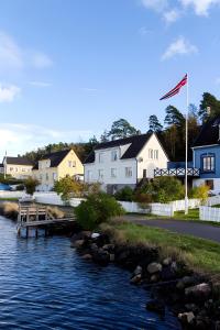 a view of a river with houses and a flag at Bolig i sjøkanten in Arendal