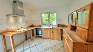a large kitchen with wooden cabinets and a window at Ferienhaus Engelhardt in Ebergötzen