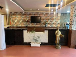 a lobby with a counter with a tv on a brick wall at Hotel The Apex,Jaipur in Jaipur
