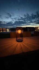 a lit candle in a glass container sitting on a table at Bolig i sjøkanten in Arendal +5 photos