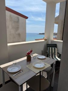 a dining table with chairs and a view of the ocean at Crisvan Home in Capo Rizzuto