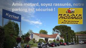 a sign with motorcycles parked in front of a building at Kyriad Digne-Les-Bains in Digne-les-Bains