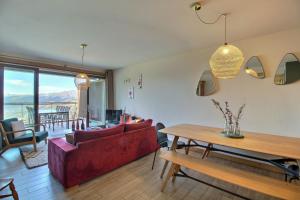 ein Wohnzimmer mit einem roten Sofa und einem Tisch in der Unterkunft ARC 1600, LE RIDGE, Appartement 08 personnes Vue Montagne - ski aux pieds - Sauna, Hammam, Piscine in Arc 1600