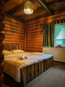 a bedroom with a bed in a log cabin at Hecaș Villas in Caşoca +94 photos