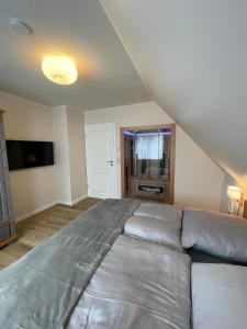プレローにあるPrerower Ferienwohnungのベッドルーム1室(屋根裏部屋に大型ベッド1台付) +6枚の写真